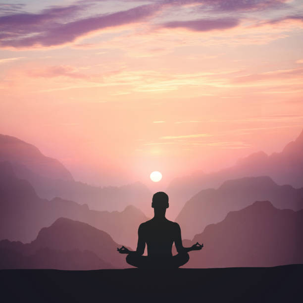 istock Man meditating on high mountain in sunset background 1143432608