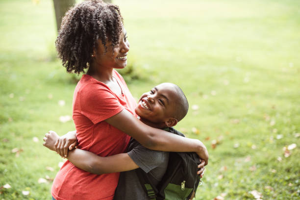 istock brother and sister embracing at the park 1143434123