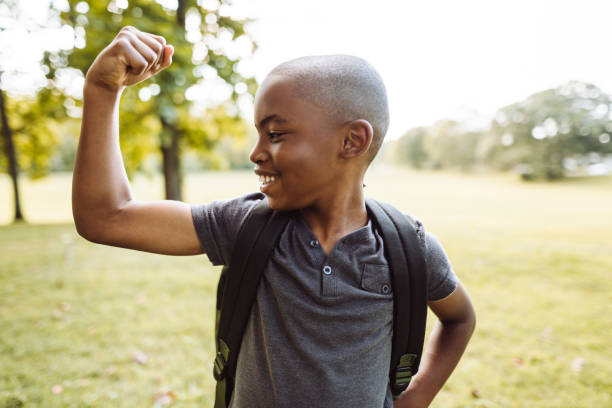 petit gosse montrant le muscle - child human muscle flexing muscles little boys photos et images de collection