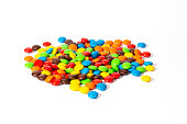 Colorful chocolate M&Ms in and out of focus on white background