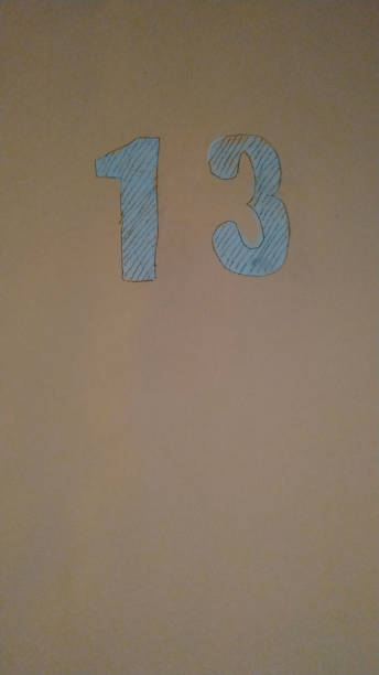 istock Number 13 painted with blue paint on a pink background. Close-up. 1143436716