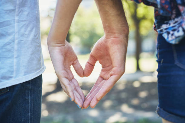 istock Hands of two young lovers make a heart shape 1143437385
