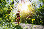 Young sporty woman jogging through the forest.