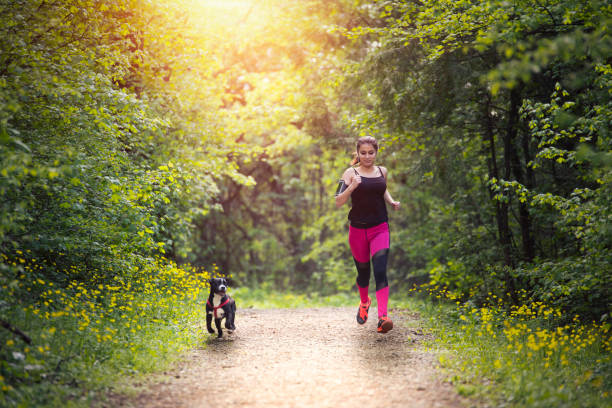 istock Young woman jogging with her dog 1143437745