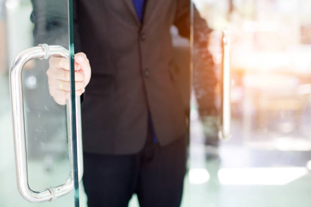 istock Man's hand open the door with glass reflection background 1143437759