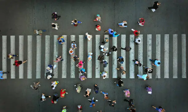 Photo of Pedestrian crowd crossing crosswalk, top view.