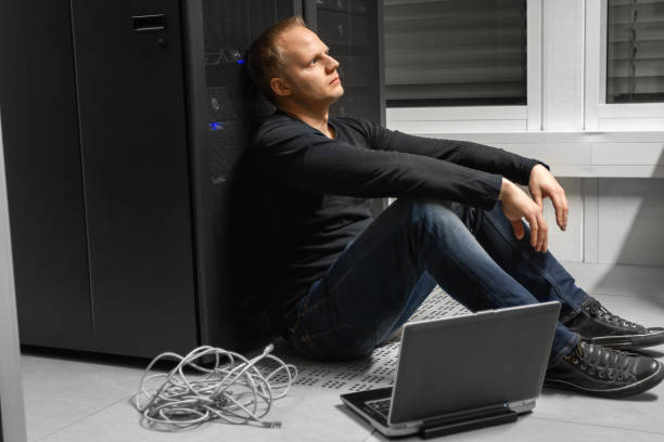 istock Exhausted Mid Adult Male IT Engineer Against SAN At Datacenter 1143440729