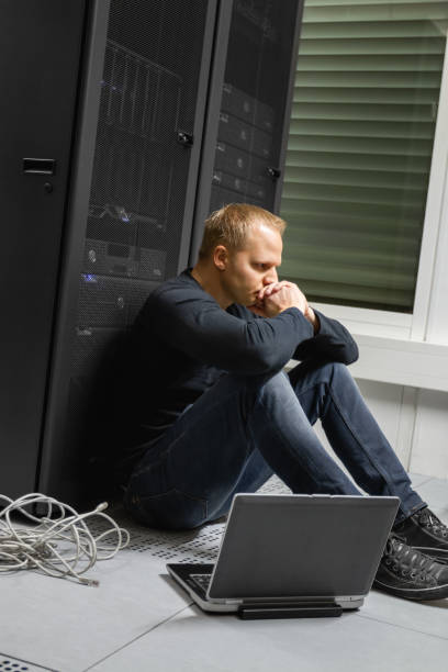 istock Exhausted Mid Adult IT Consultant Against Servers At Datacenter 1143441077