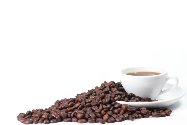 taza de café y frijoles sobre un fondo blanco, una taza de café y una pila de granos de café, espacio para el texto - menu bean brown caffeine fotografías e imágenes de stock
