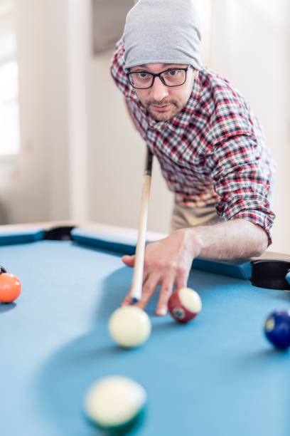 istock Fashionable urban man playing pool table billiards game. 1143458914