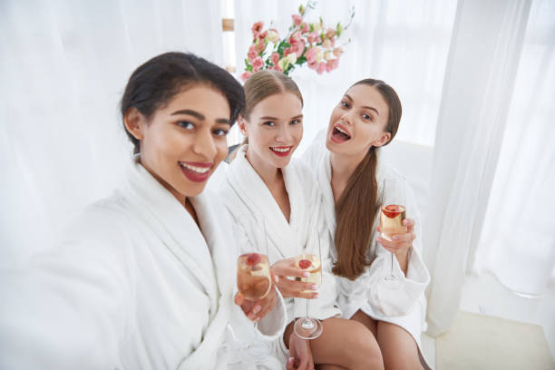 istock Cheerful girls with alcohol drinks posing at spa salon 1143460694