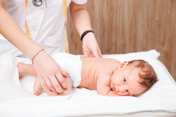 infant medical exam - pediatrician checking little baby hips in pediatric clinic - physical checkup imagens e fotografias de stock