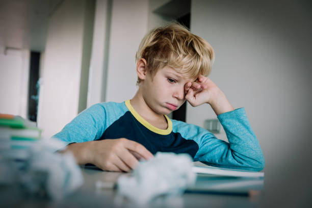 小さな男の子は、書き込み、宿題をして疲れたストレス - learning boredom studying child ストックフォトと画像