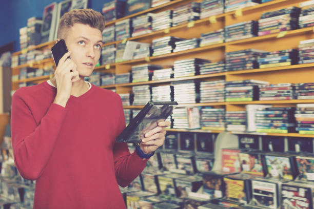 istock Glad guy talking on mobile phone in shop 1143463099