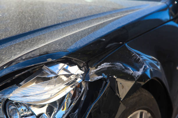 car crash or accident. front fender and light damage and scratches on bumper. broken vehicle- close up. - fender bender imagens e fotografias de stock