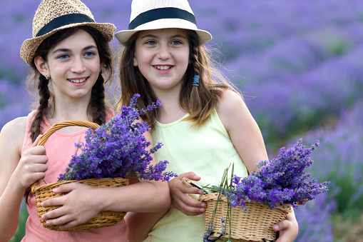 Two happy and beautiful girls having fun in lavender field