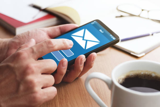 istock Closeup of male hands touching smartphone screen for using email app at table. 1143467038