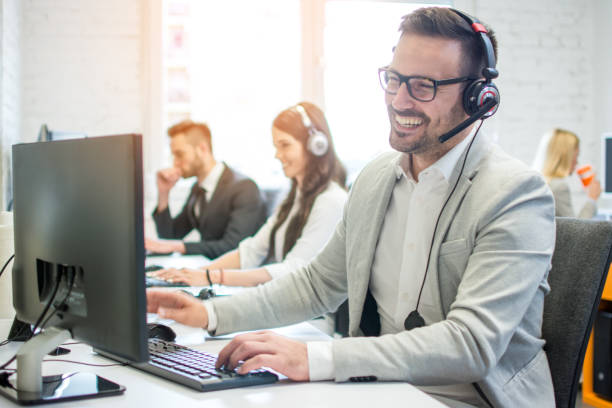 istock Cheerful friendly online technical operator agent with headphones and microphone talking with client in customer support office 1143467993