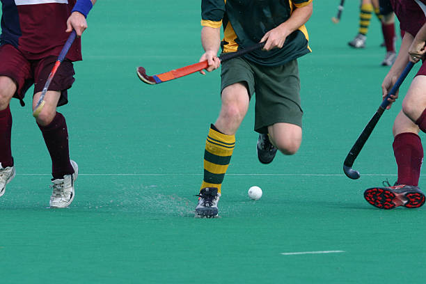 field hockey Three players contest for the ball in a game of field hockey. field hockey stock pictures, royalty-free photos & images