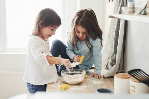 istock Having fun during the process. Preschool friends learning how to cook with flour in the white kitchen 1143468556