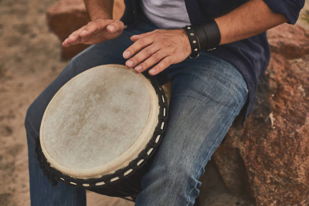 istock Man jamming with percussion drum sitting on the stone 1143469688