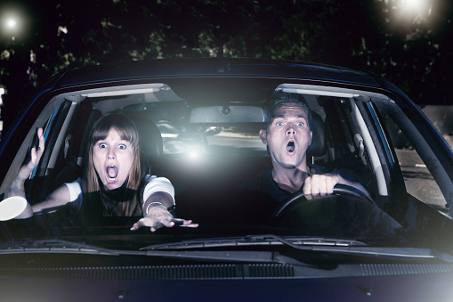 A screaming young couple in a car at night try desperately to avoid having an accident.