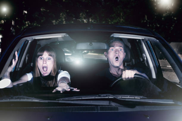 Terrified young couple in car try to avoid crash A screaming young couple in a car at night try desperately to avoid having an accident. couple driving at night stock pictures, royalty-free photos & images