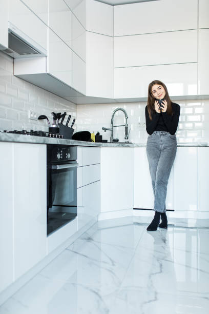 istock Young woman drinking tea in kitchen in the morning 1143470143