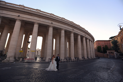 Beautiful wedding couple posing on street near old historic columns