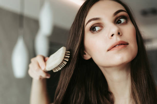 istock Focused woman combing long dark hair indoor 1143473073