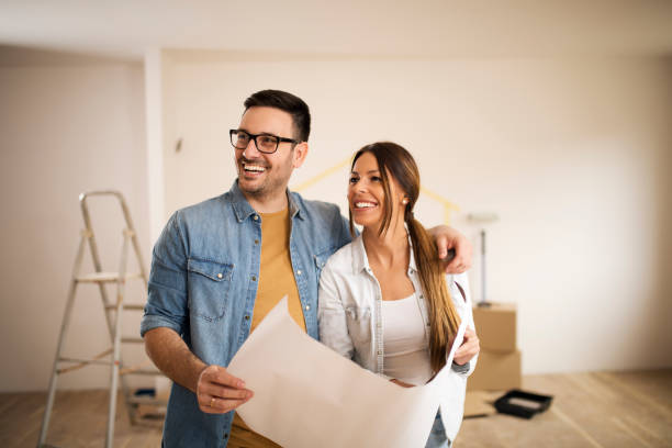 istock Couple smiling and holding an architectural project 1143474044