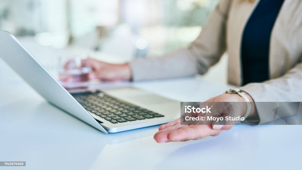 Her daily vitamins allow her to perform at her best Cropped shot of an unrecognizable young businesswoman taking medicine while working in her corporate office 20-29 Years Stock Photo