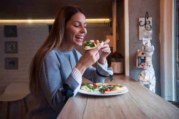 woman eating pizza. - morning tomato lettuce vegetable imagens e fotografias de stock