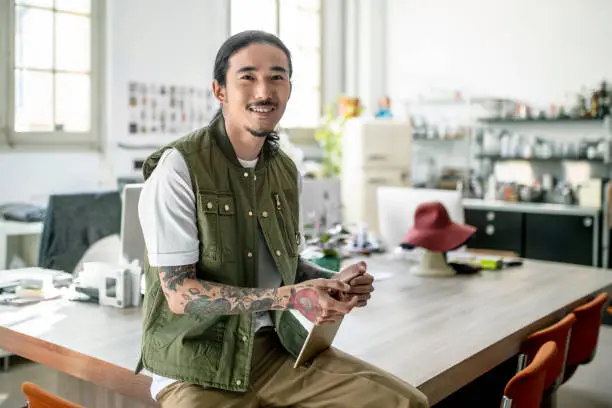 Photo of Portrait of smiling designer with digital tablet