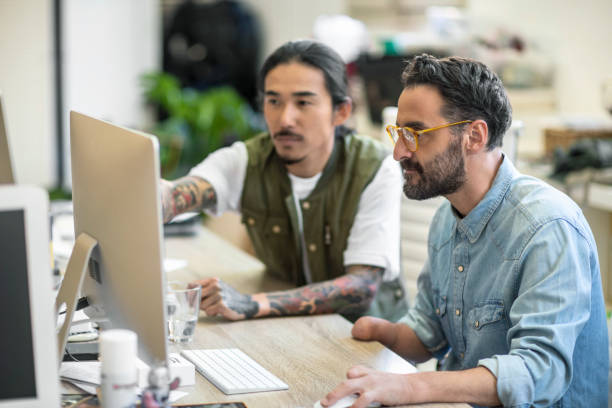 istock Male executives discussing over computer at desk 1143476209