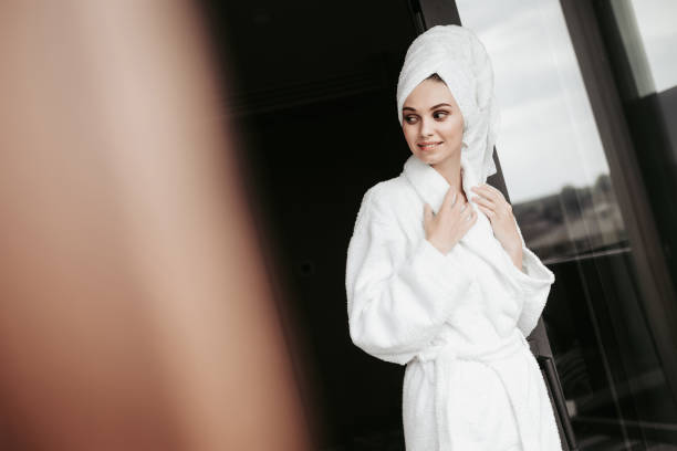 istock Young woman in bathrobe standing on terrace 1143476264