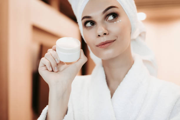 istock Young woman applying cream on face after shower 1143476308