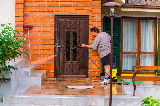Man Cleaning House with Water Spray Mid Aged Manual Worker Cleaning Building Exterior with Water Hose and Spray pressure washing house stock pictures, royalty-free photos & images