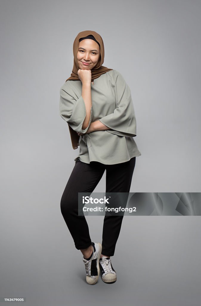 Muslim girl posing and smiling in front of camera isolated on grey background Women Stock Photo