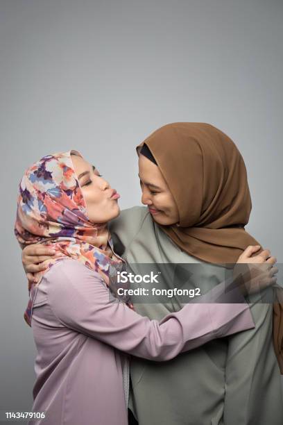 Portrait Of Attractive Two Young Muslim Girl Having Fun Together Isolated On Grey Background Stock Photo - Download Image Now