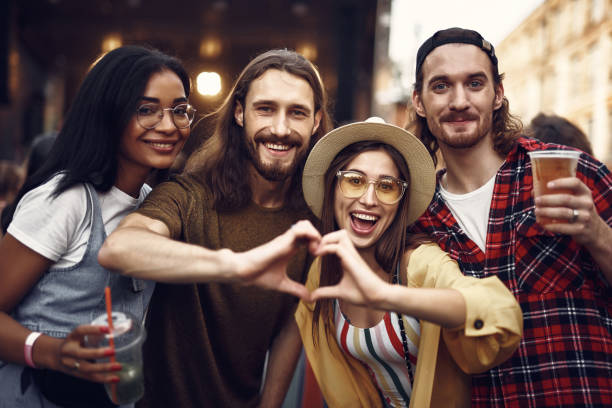 istock Beautiful couple showing heart symbol while spending time with friends 1143480606