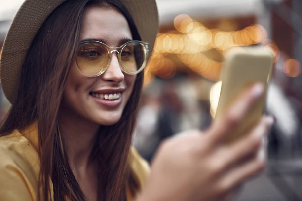 istock Pretty girl in glasses using cellphone on blurred background with bokeh effect 1143480643