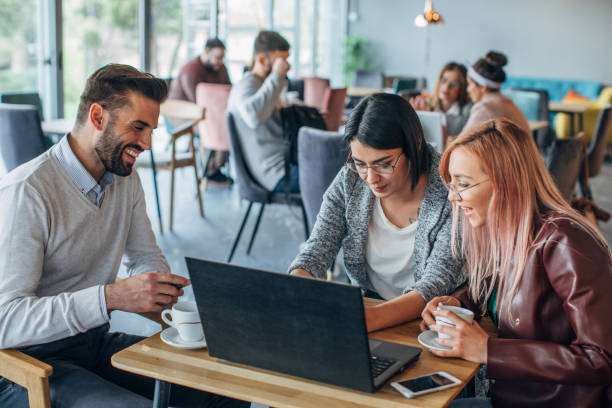 istock Group of friends working on laptop in cafe 1143480888