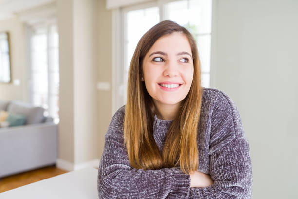 istock Beautiful young woman at home smiling looking side and staring away thinking. 1143481021