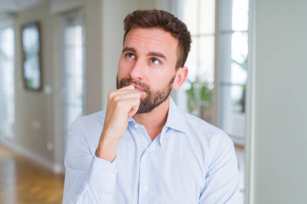 istock Handsome business man with hand on chin thinking about question, pensive expression. Smiling with thoughtful face. Doubt concept. 1143482299