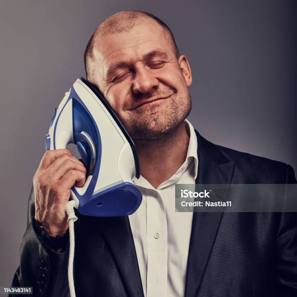 Bald Fun Happy Comic Business Man Holding The Home Iron Near The Face With Love In Suit On Grey Background Closeup Portrait Perfec Husband Stock Photo - Download Image Now