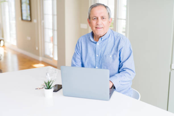 istock Handsome senior man using laptop and smiling 1143483938
