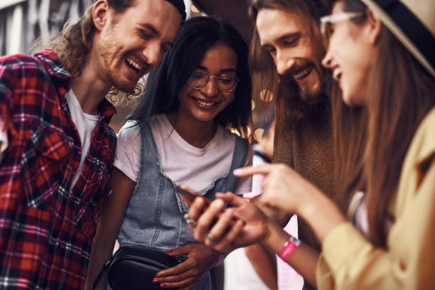 istock Four people laughing while watching funny video together 1143487087