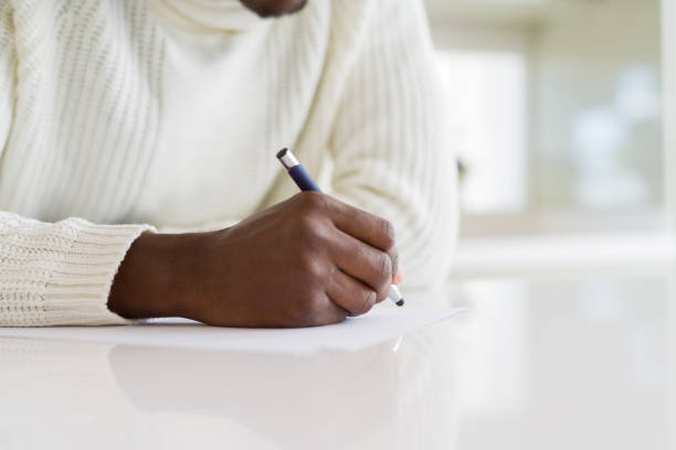istock Close up of african man writing a note on a paper 1143488026