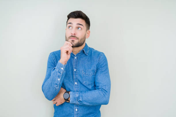 istock Young handsome man over isolated background with hand on chin thinking about question, pensive expression. Smiling with thoughtful face. Doubt concept. 1143491972